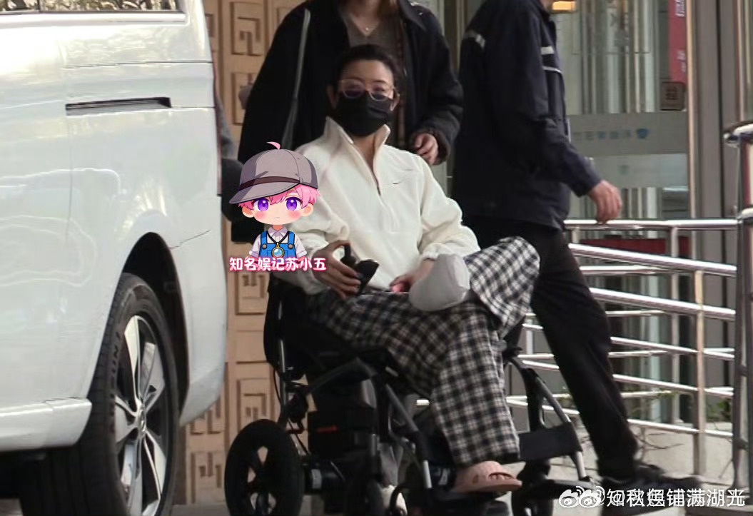 陈妍希坐轮椅就诊  陈妍希脚部打着石膏坐着轮椅在医院就诊，在工作人员的帮助下她上