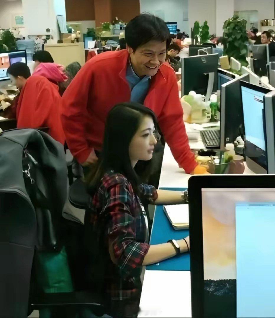 2014年，小米创业初期，雷军俯身查看员工工作时的一幕，网传坐着的这名女工程师叫