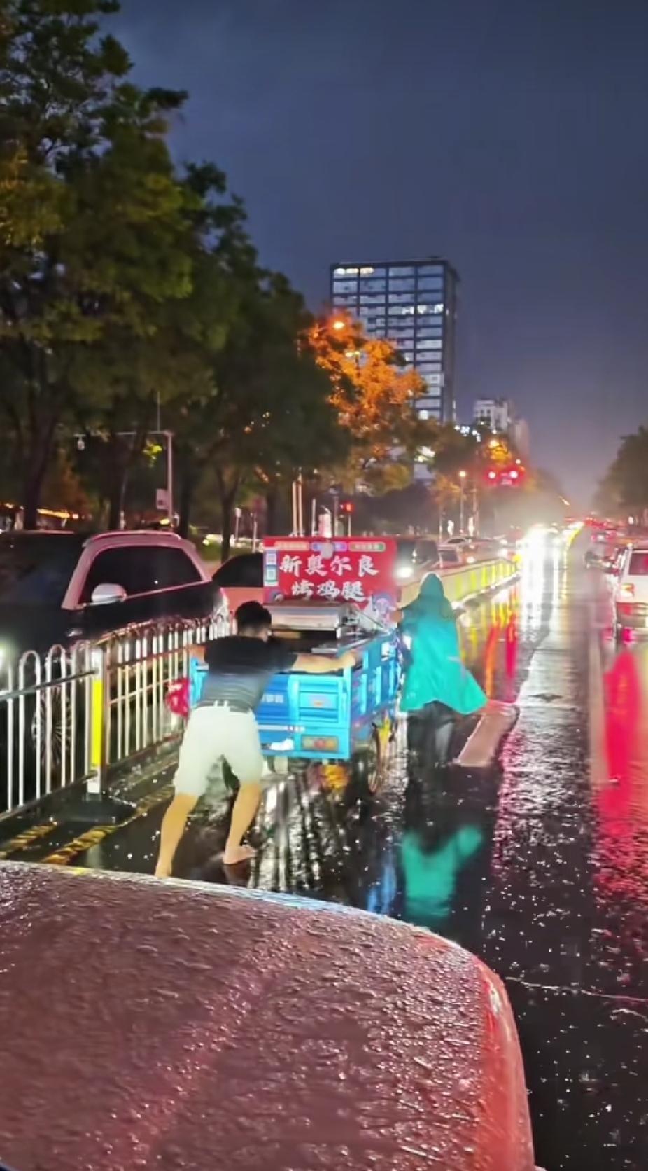 大雨中，男子突然停车，拉开车门向前面的炸鸡腿摊车跑去，看到的一幕，却让路人直呼感