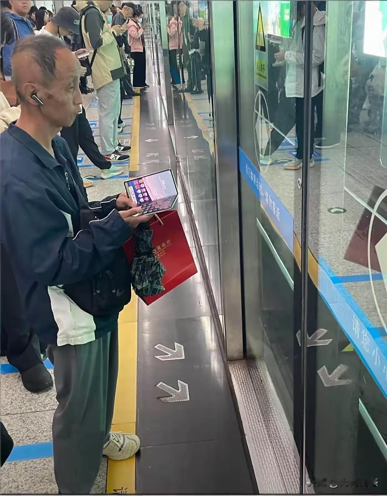 大哥的头型比较新，看起来也是一个很时尚的人，虽然穿着打扮很普通，但是看他手里拿着