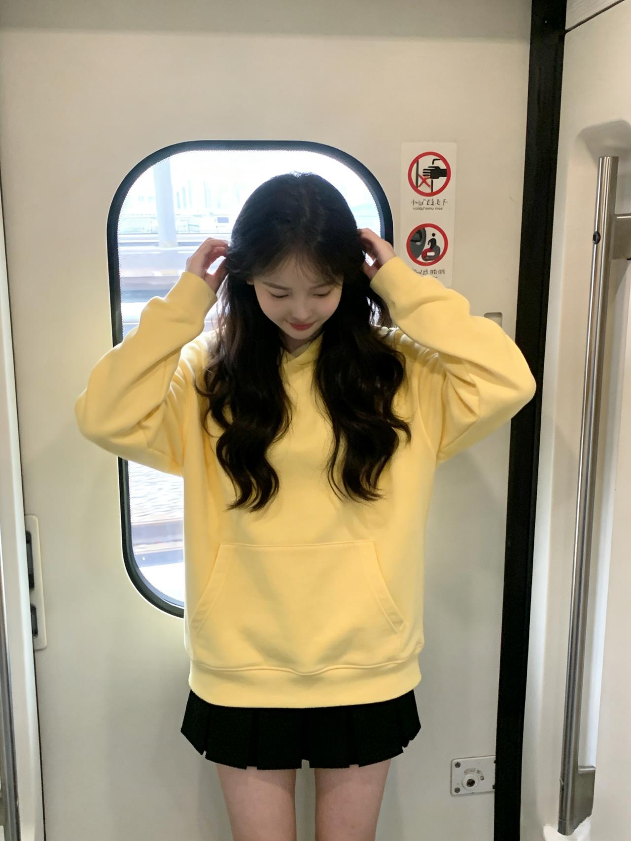 列车的门是时间的切口，她站在中间
黄卫衣洇开的暖，漫过金属的凉
手指梳过卷发，像