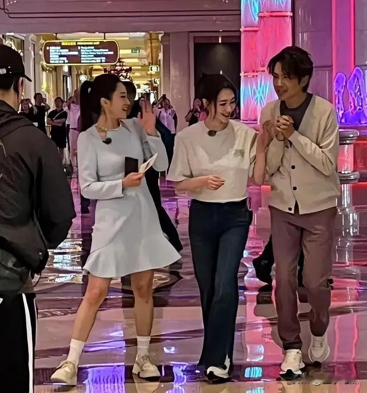 照片中中间穿白色衣服的是肤白貌美年年都一样的李小冉，右边这位穿着毛线衣的是大家公