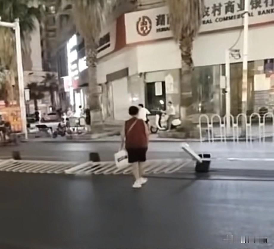 湖南，一女子为了抄近路横穿马路，竟然直接把路中间的隔离护栏给扳倒了。更离谱的是，