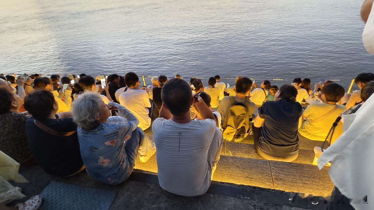 夏天的松花江边，
人长流，水长东。
台阶不走，变长凳。
五湖四海齐汇聚，
为啥坐