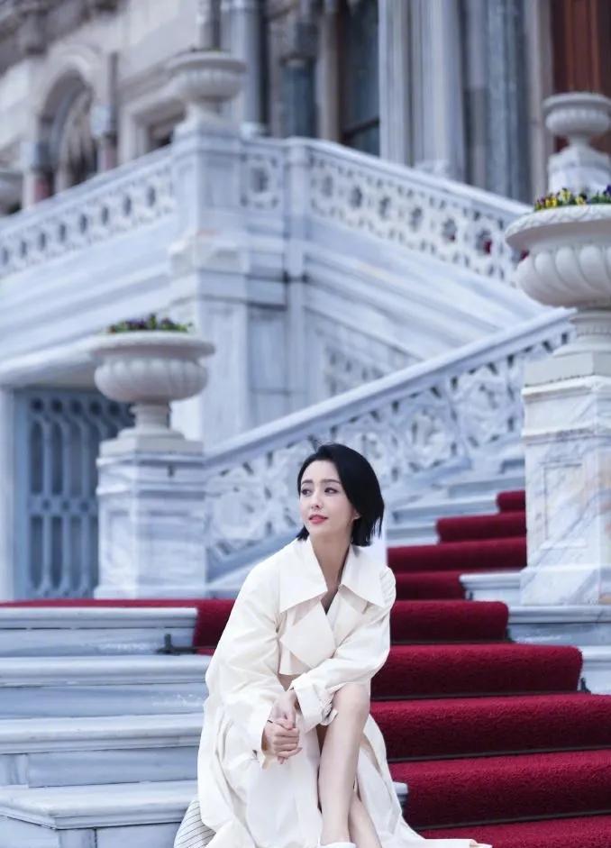 佟丽娅穿白风衣，没化妆也没修图，直接杀疯了。
短发，露腿，小白鞋，站在798的灰