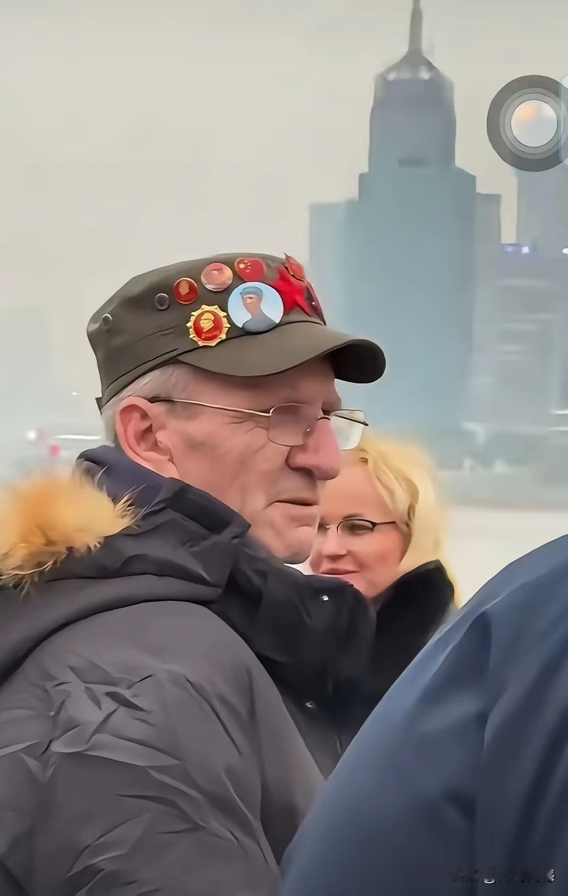 这个外国老头的帽子上，佩戴着不少像章，这都是我们非常熟悉的像章，他把这些佩戴在自