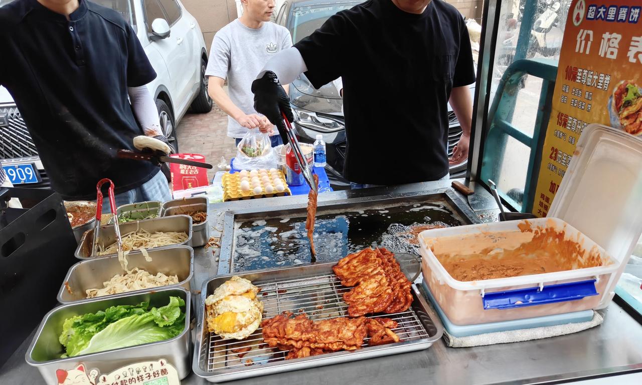 淮河新城那边一路口，新开了一家“加大鸡柳肉夹馍”摊位。大片腌制好的鸡柳，一个荷包