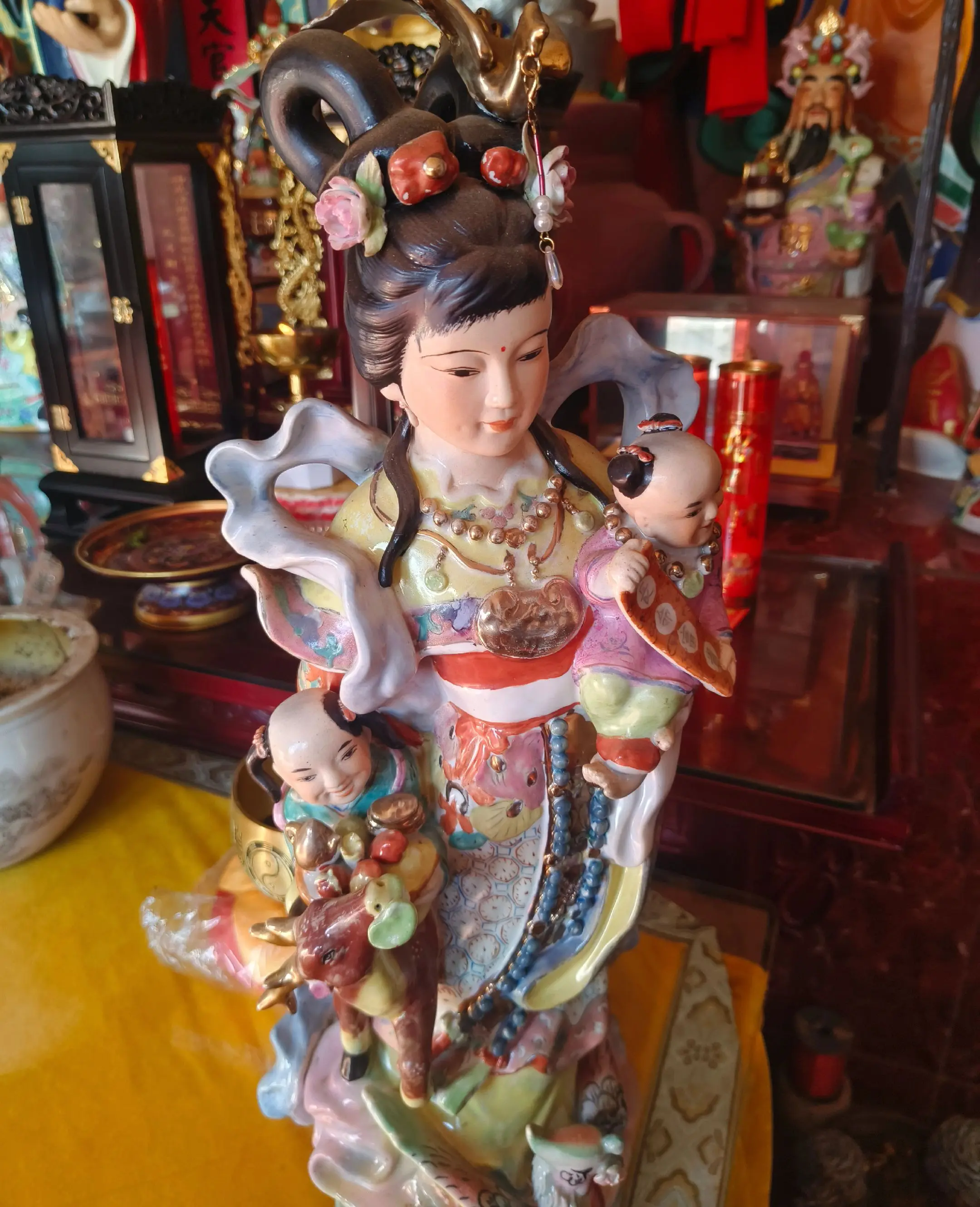 仙姿玉貌踏云来，手抱麟儿福满怀。