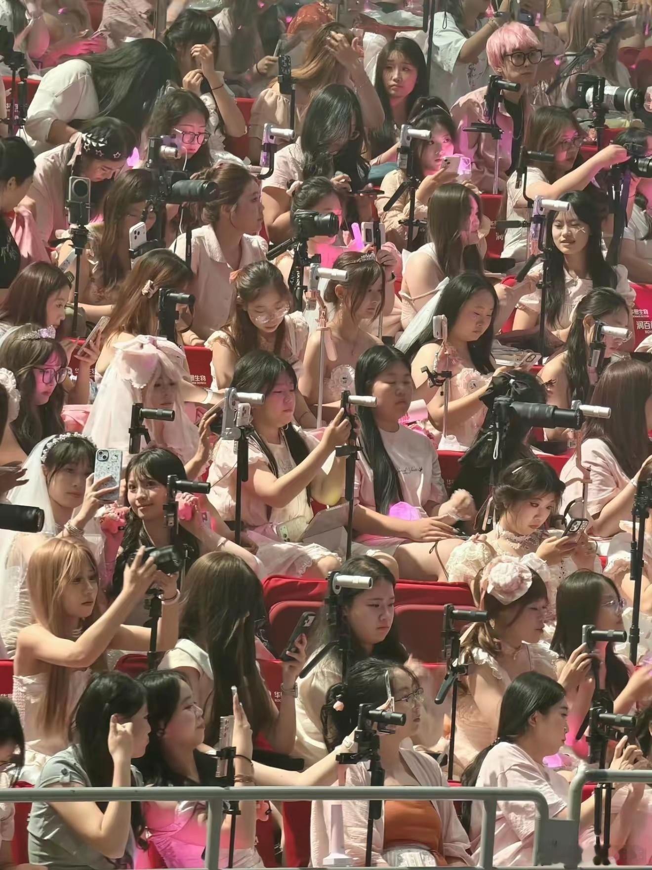 在演唱会上的女生们人手拿着一颗大炮，除了专业相机单反，还有vivo的增距镜套装这