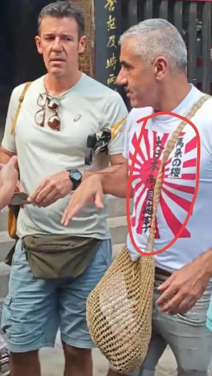 一名外籍游客穿印有日本军国主义标志的衣服在平遥古城闲逛，暴露出两个问题，一，这件