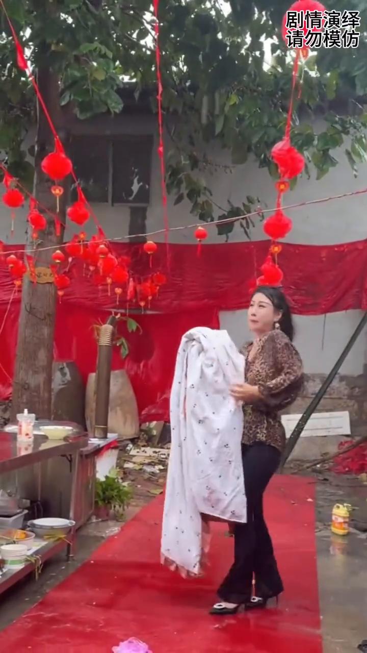 女子下雨天在晒被子，这一幕真的太搞笑了。
外面正在下大雨，这时女子拿着被子走出来