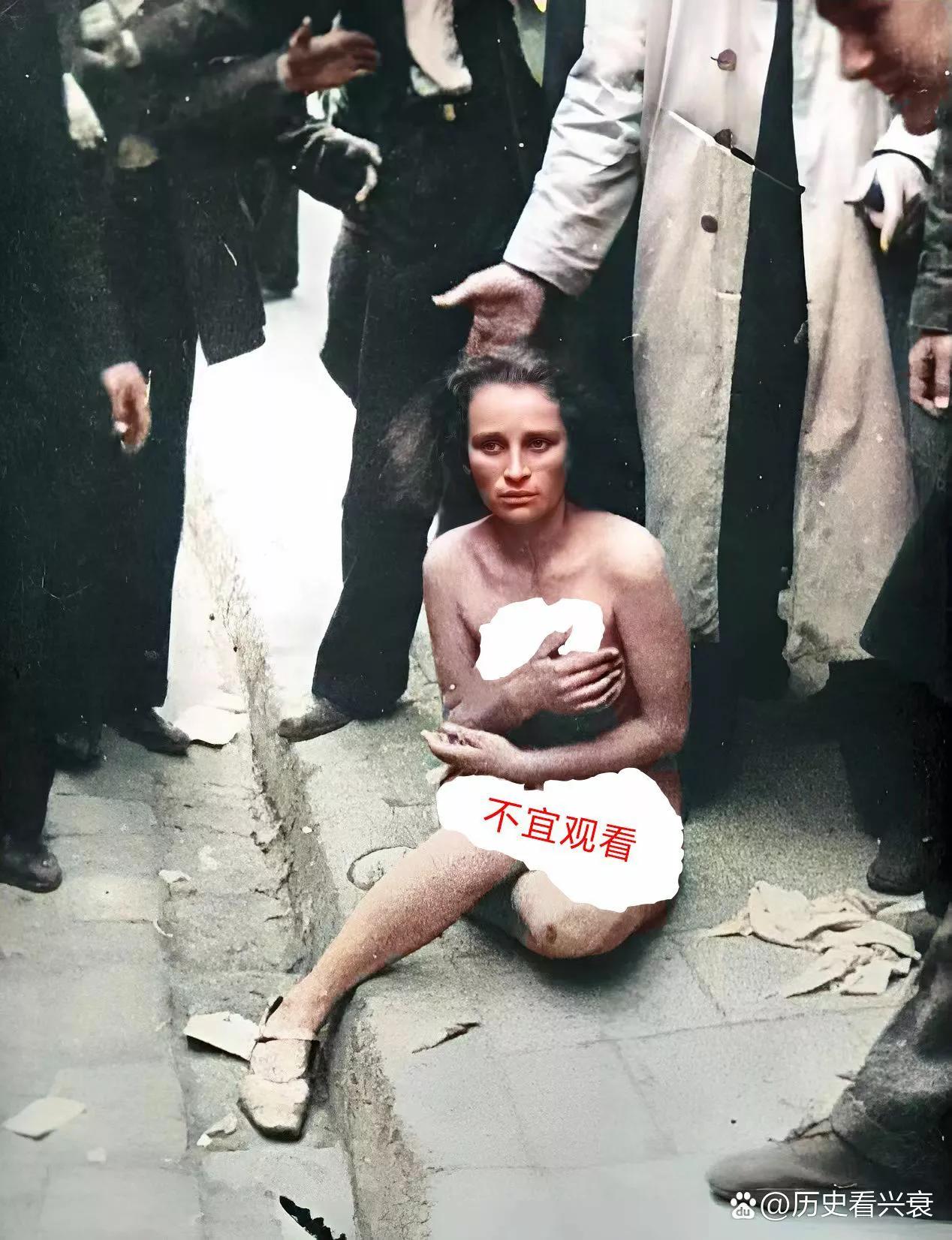 1944年，一个法国女性被扒光了衣服，无助的坐在街头。

在这个女子的周围站满了
