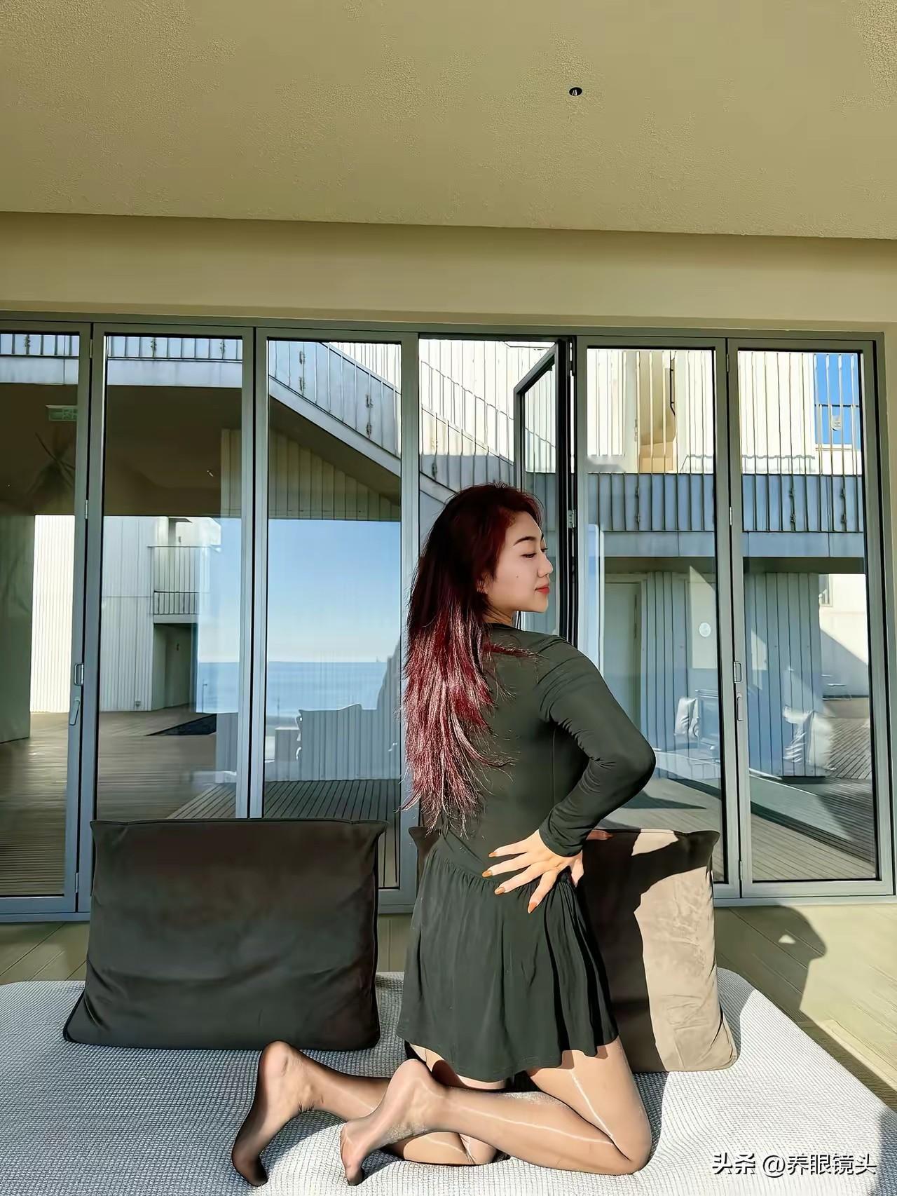 阳光洒进阳台，红发少女优雅地坐在沙发上，享受宁静时光。