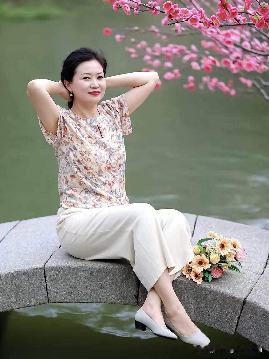 她坐在湖边，手托着头，看着花。