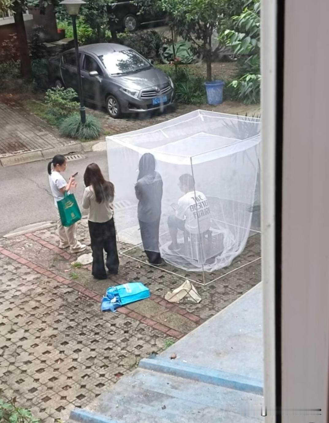 这一家子人都这么闲？为了占一个小区地面车位，连蚊帐都用上了