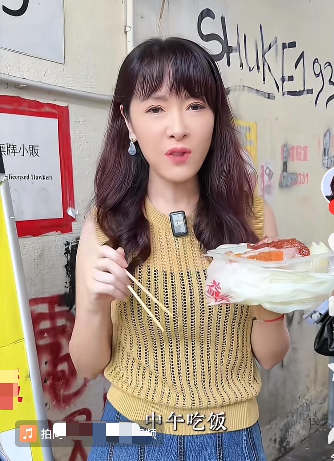曾经风光无限的港姐向海岚，

如今拍短视频也非常接地气，和普通人一样站在路边吃起