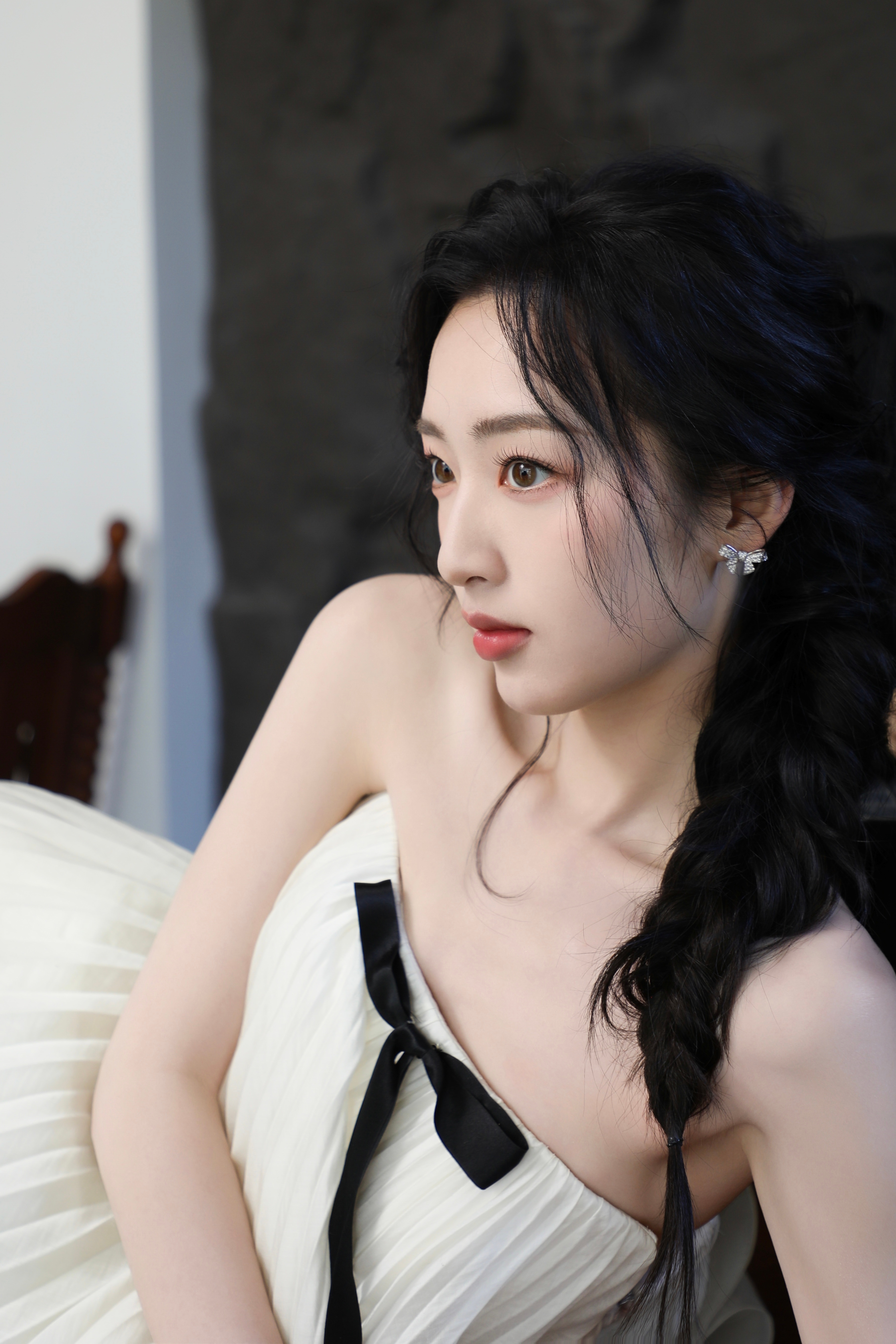 邓恩熙 黑蝴蝶结在白裙间轻缀，麻花辫挽起温柔，她似从复古梦境中走来，于光影里漾开