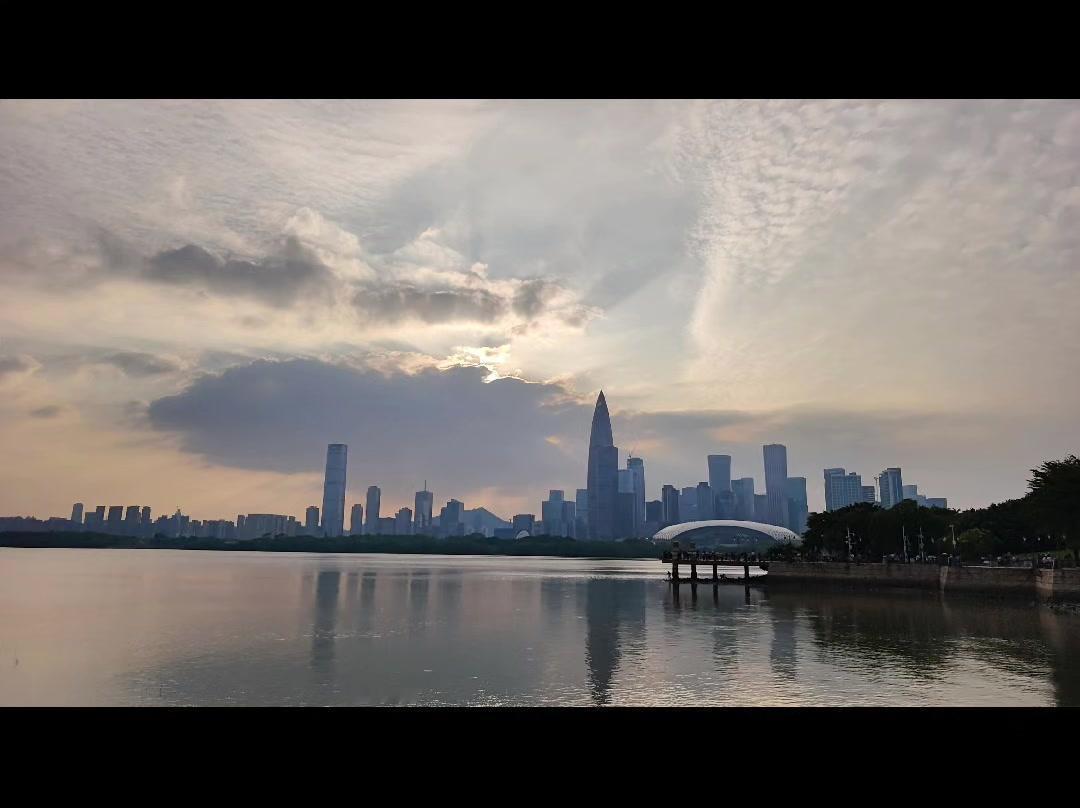 踱步深圳湾畔，人才公园的滨水栈道被夜色晕染。晚风裹着水汽掠过肩头，脚下木质栈道蜿