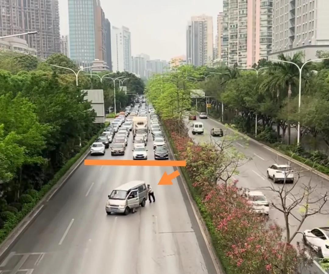 广西南宁主车道上一交警帮推熄火的面包车，其他车辆一字排开等候不抢行。