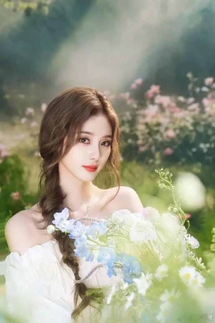 文亦娱乐徐艺洋穿白裙与花海合照 光影衬出灵动氛围感 