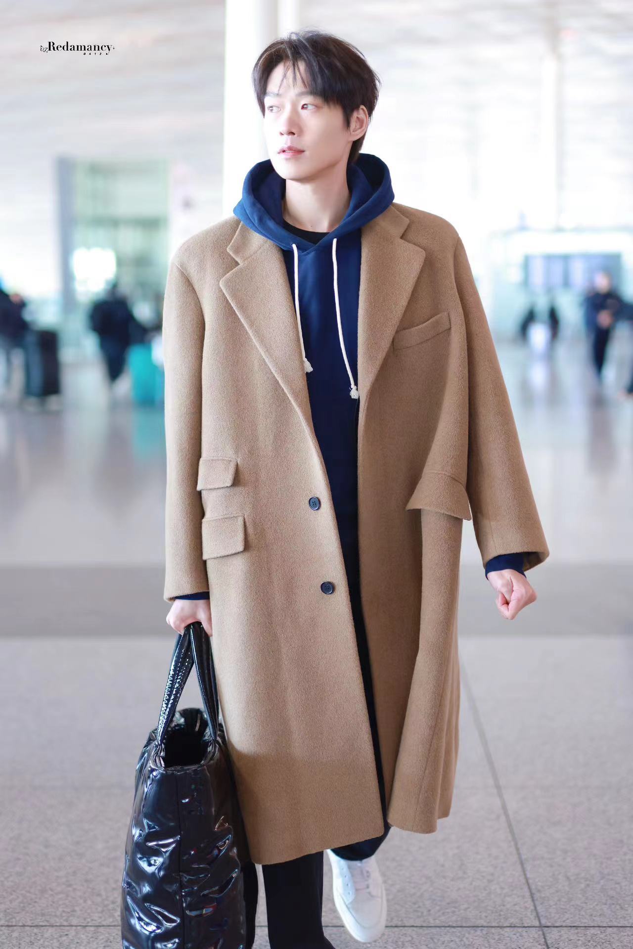 #魏大勋机场像秀场# 魏大勋驼色大衣内搭蓝色卫衣造型出发巴黎时装周，一路顺风，期