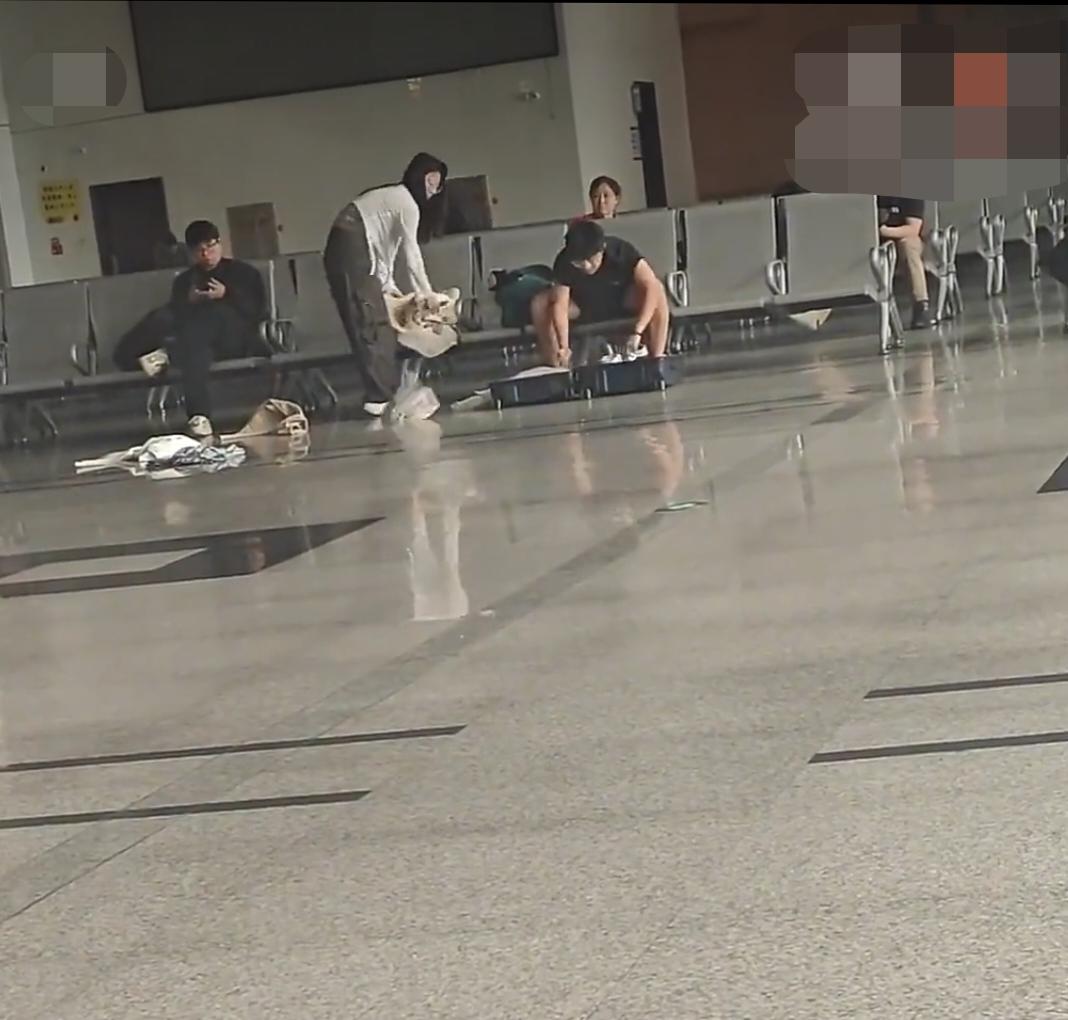 候车室内人来人往，一对情侣突然爆发激烈争吵，情绪失控的男生直接拉开行李箱，将女生