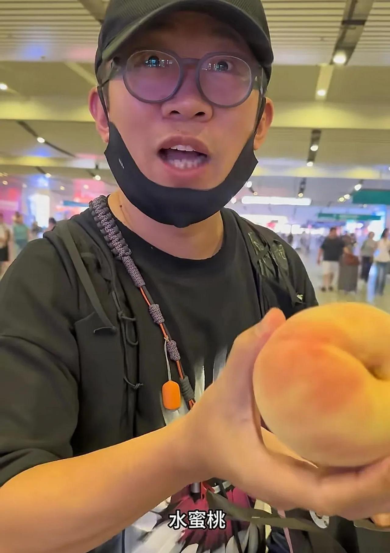 粉丝在机场接杨迪，杨迪从包里掏出一个水蜜桃递给粉丝说：“你们两个切一下，一个人吃