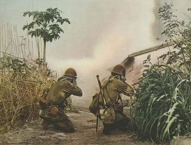 1941年入侵菲律宾期间，两名日本鬼子工兵向前方炮弹爆炸产生的烟雾射击。