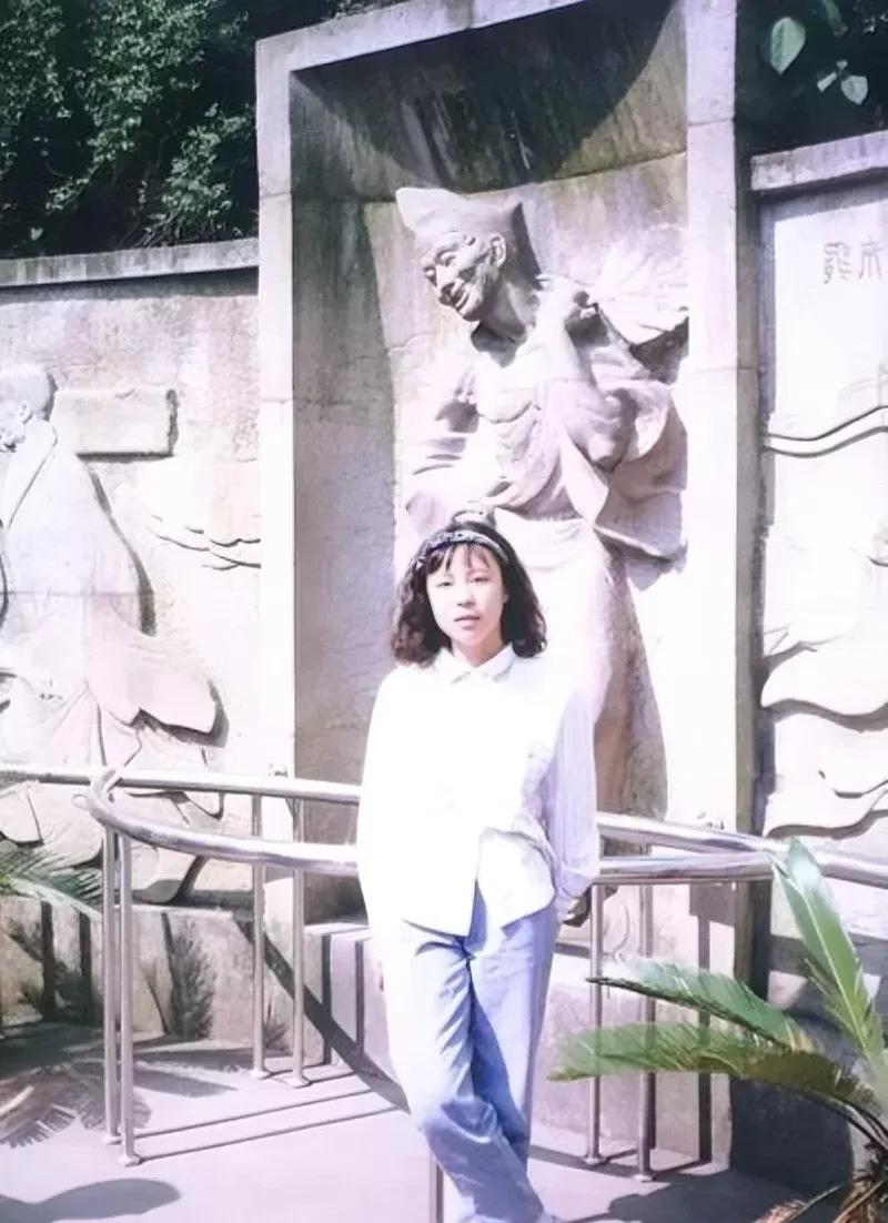 90年代，朱令在天台济公故居的合影，她穿着白衬衫，面容青涩，背后就是济公活灵活现
