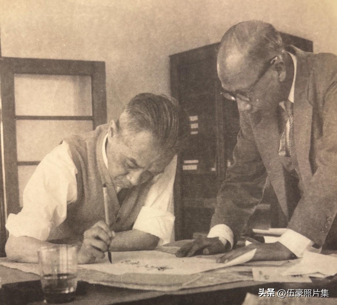 1958年5月，胡适题字时留影，右为秘书胡颂平。胡适的字如其人，清癯削瘦，且相当