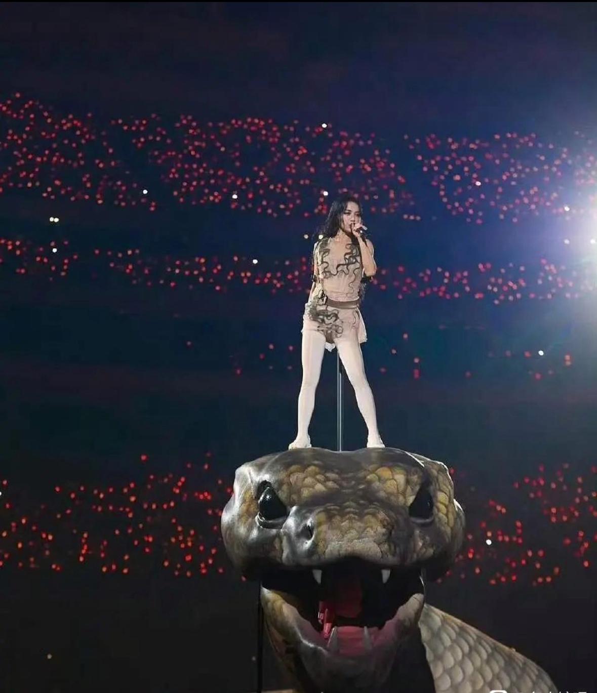 踩蛇颅而歌，她把巨蟒踩成王座，红海浪潮在身后翻涌。
麦克风攥住全场心跳，白袜裹着