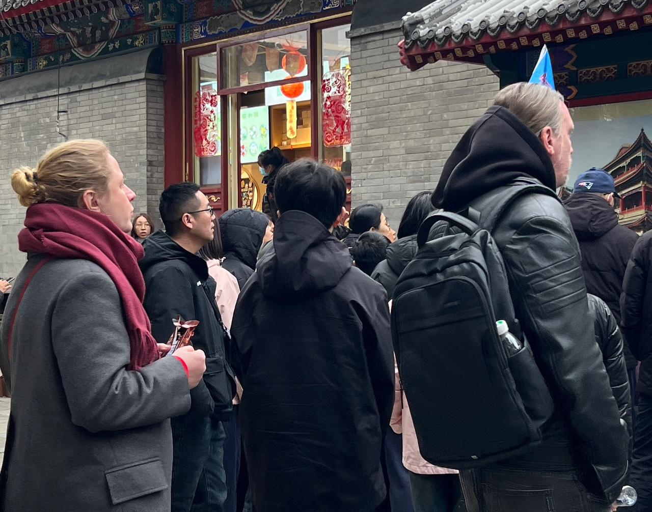 强盗的后代们站在园区里写着＂被英法联军烧毁＂或＂被八国联军掠夺、烧毁＂的揭示牌前