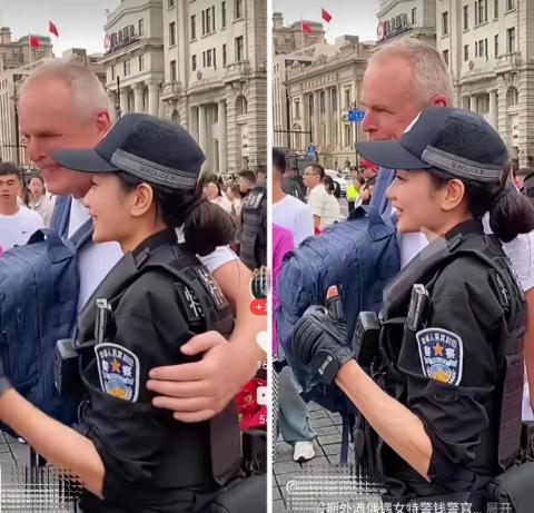 国庆外滩人潮涌动，一名外国游客与执勤女特警合影时，突然伸手想搭她肩膀。女特警没有