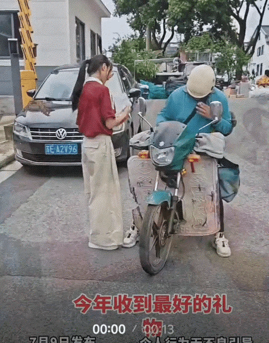 一快递员为女生送来高考录取通知书，而女生下来拿通知书时，为了分享自己这份金榜题名