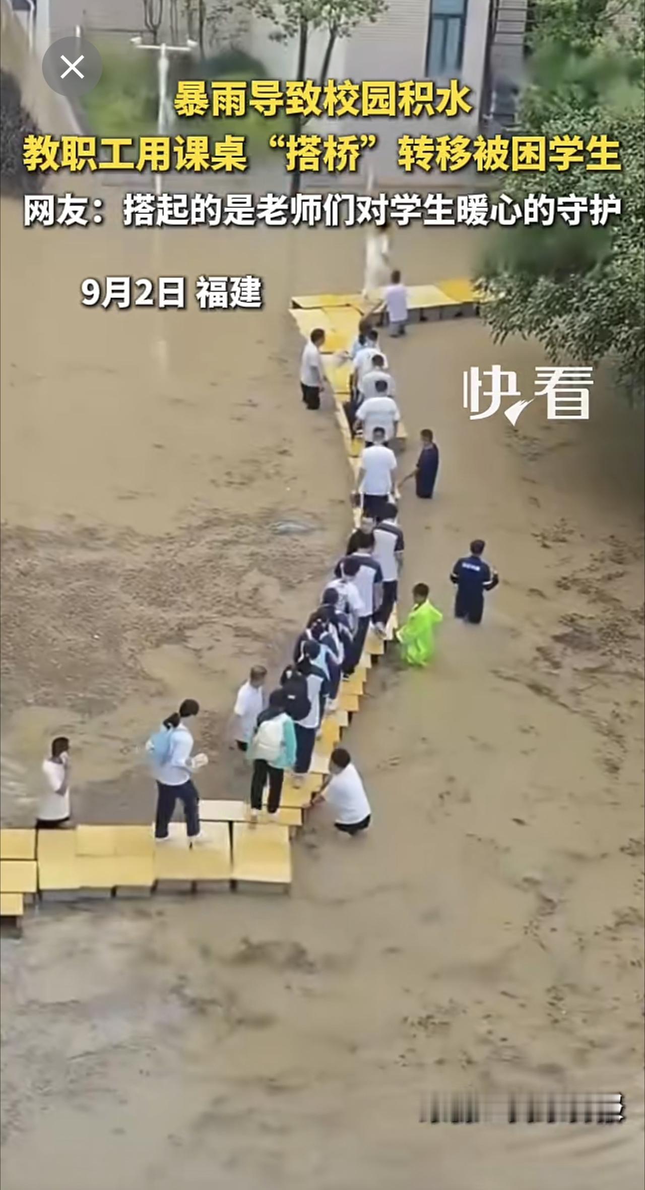 暴雨导致校园积水，教职工用课桌“搭桥”转移被困学生。网友：搭起的是老师们对学生暖