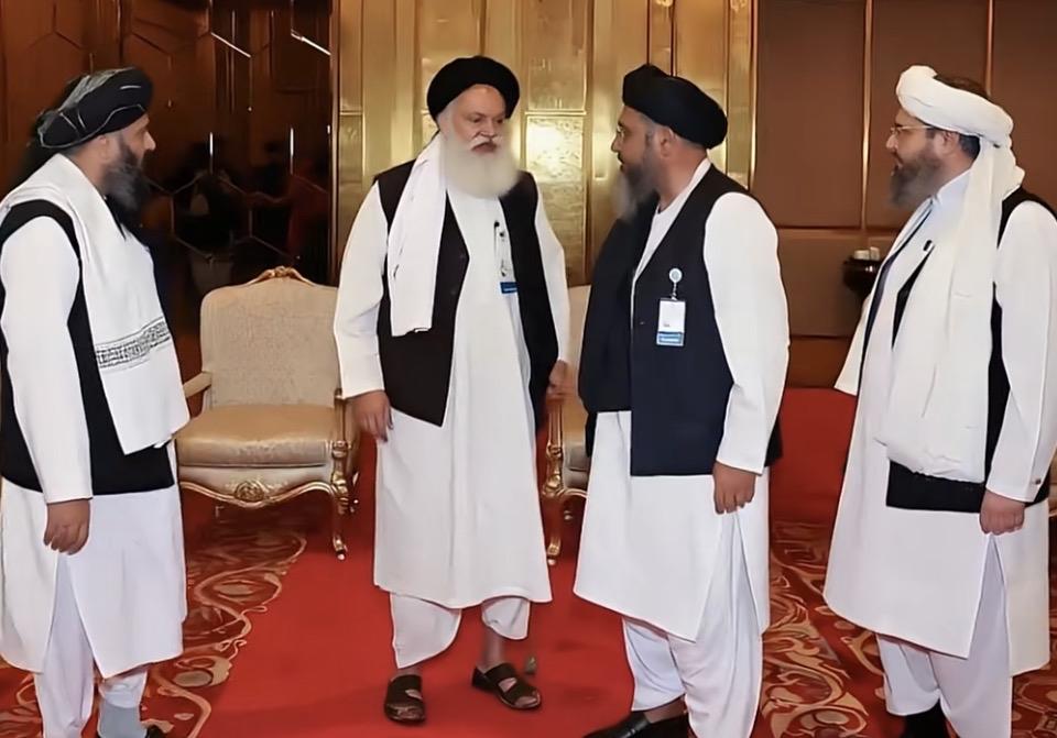 以对话消弭分歧，以沟通寻求共识。身着传统服饰的各方代表，在庄重的场合中交流协商，