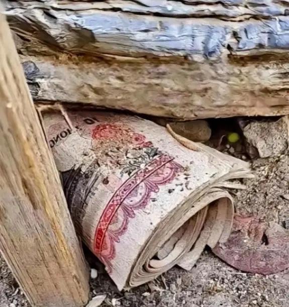 贵州，一男子拆除祖屋老房子时，意外从过世多年奶奶的床板缝里翻出一沓过期的钞票，这