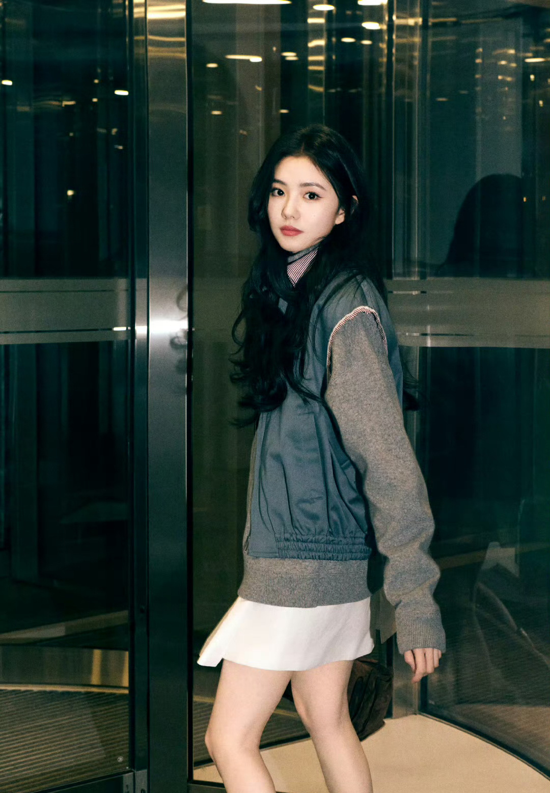 刘浩存出发巴黎时装周，一身甜酷风穿搭现身机场，大波浪发型搭配短裙长靴，整体造型又