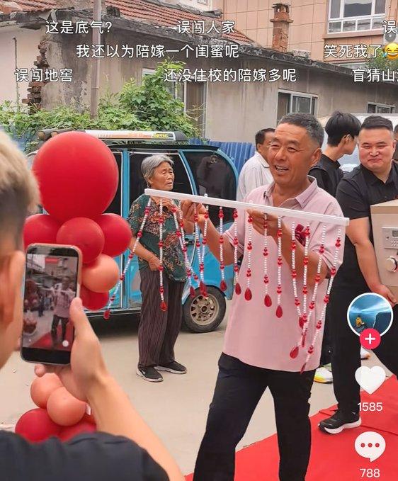 婚礼现场一幕引发不少讨论。
姑娘手里捧着一块红色牌子，上面写着闺蜜送来的陪嫁：螺