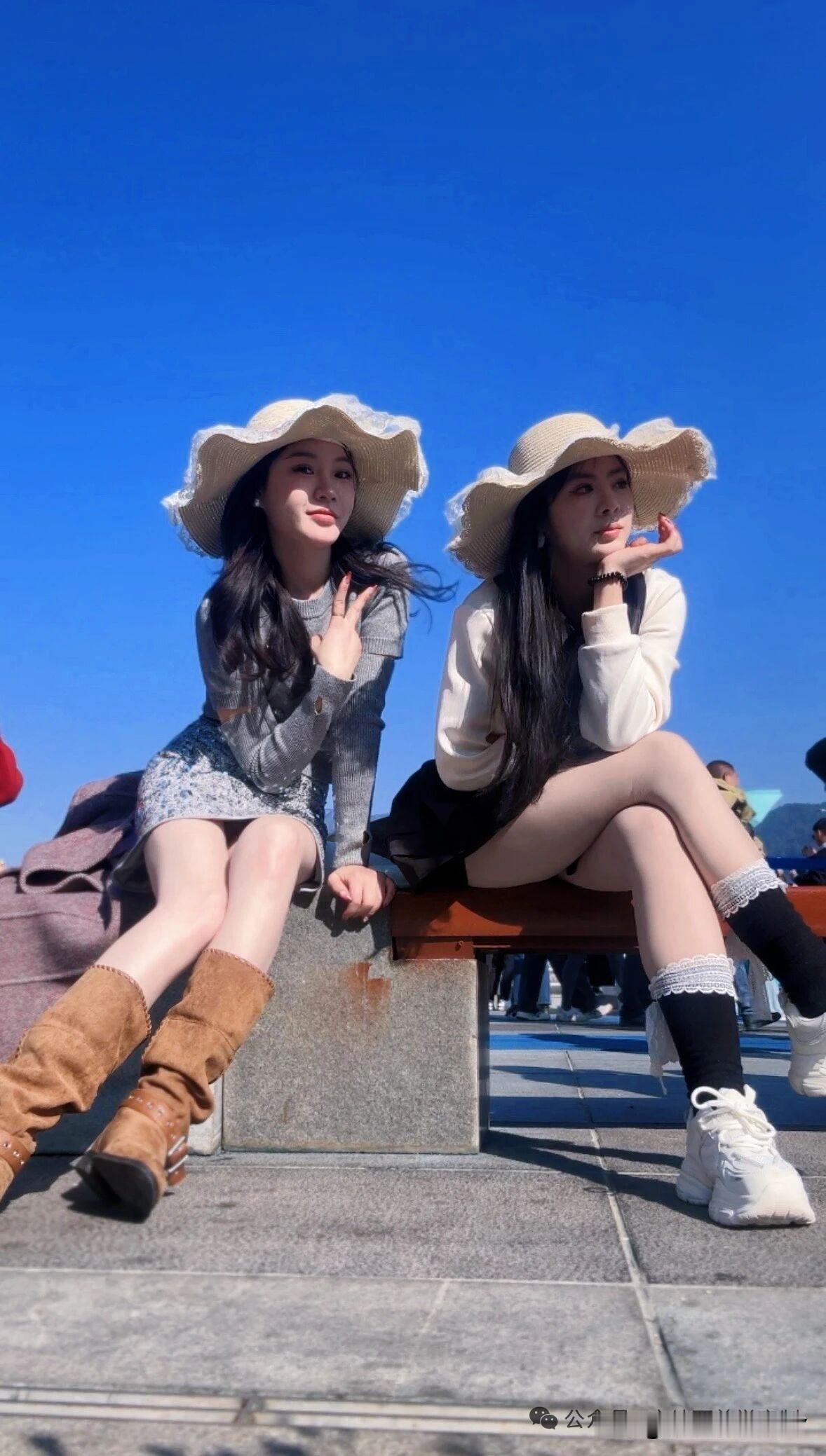 阳光明媚的午后，两位姐妹在海边享受悠闲时光。