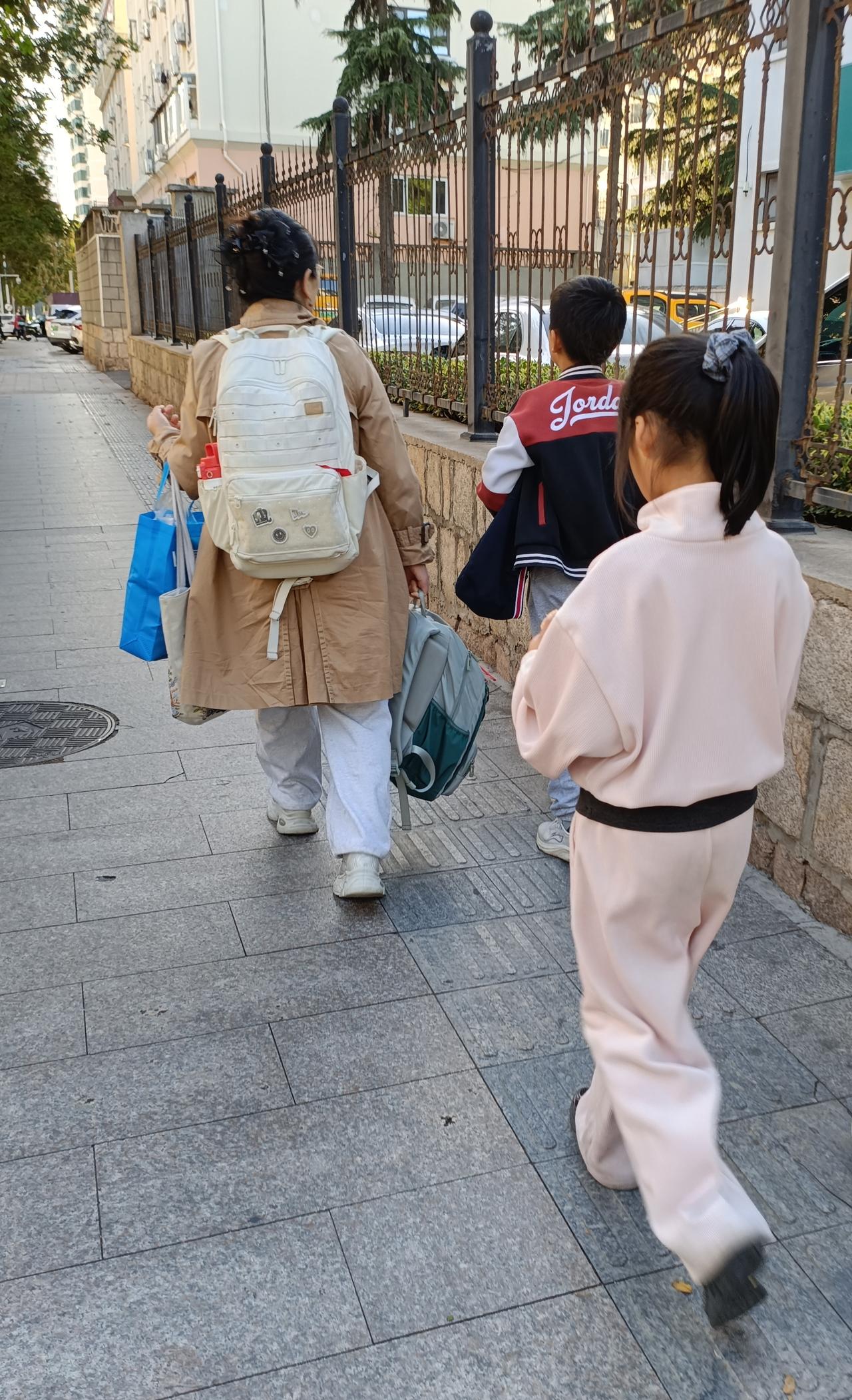 接孙女放学的路上，前面走着一位两个孩子的家长，两个孩子都不小了，应该有10岁左右