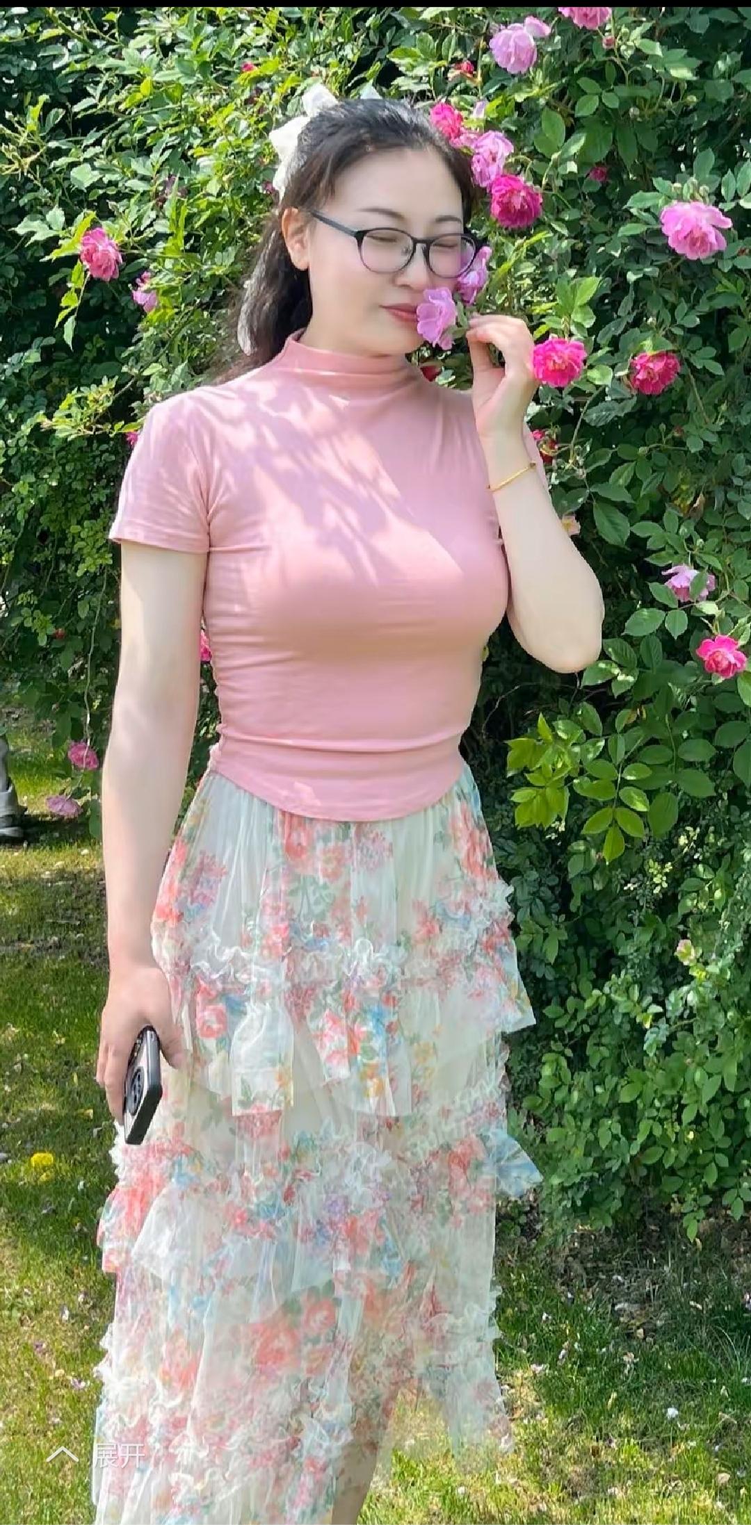 粉衣美人倚花丛，笑语盈盈似画中。
