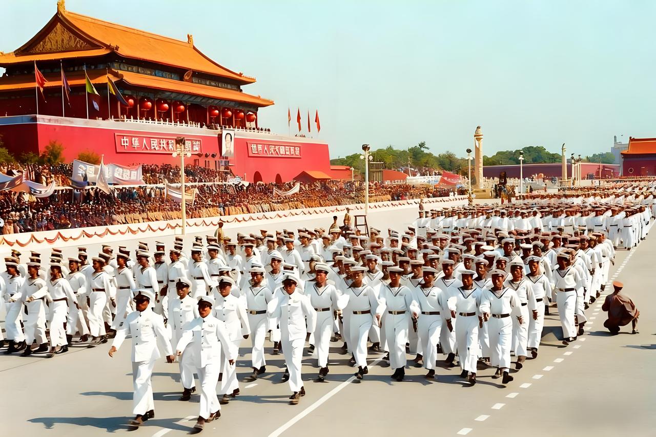 这张照片定格了1950年国庆阅兵式的一幕：解放军海军学校的官兵身着洁白的制服，队