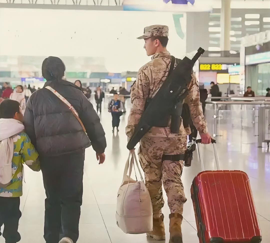 这张照片是今年春运期间的，他身上穿的是我军新一代的21式荒漠星空迷彩作训服，搭配