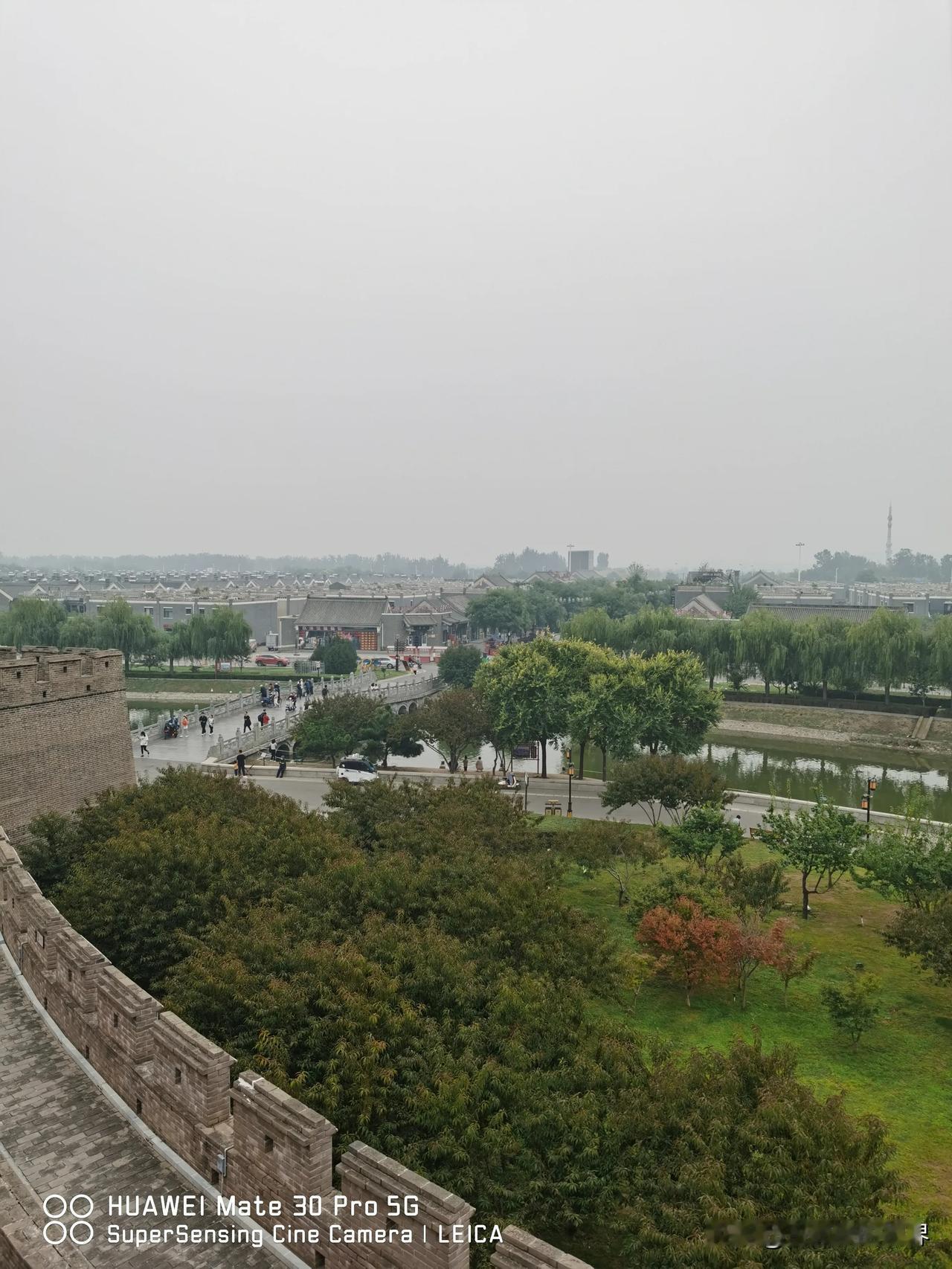 古城中的建筑与秋日的自然景观相互交融。红墙黄瓦的古建筑在秋日阳光的照耀下，色彩更