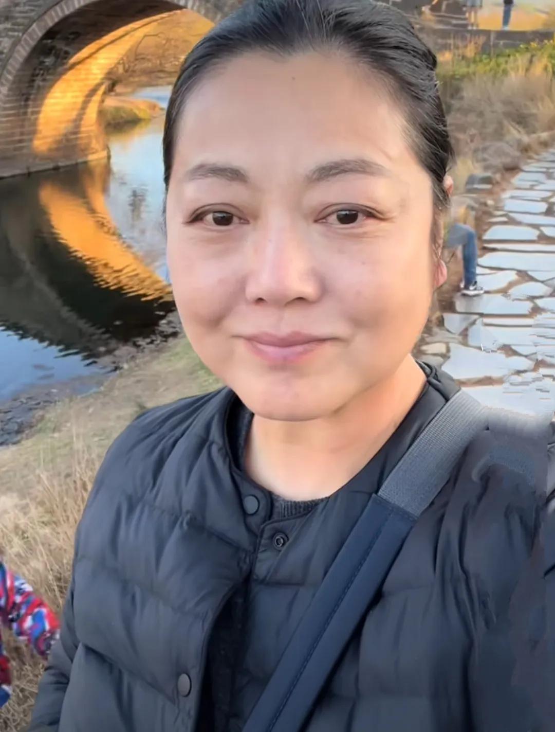 王茜华在个人社交软件晒无美颜照，身穿蓝色薄款羽绒服，斜挎背包，无美颜滤镜，自然大