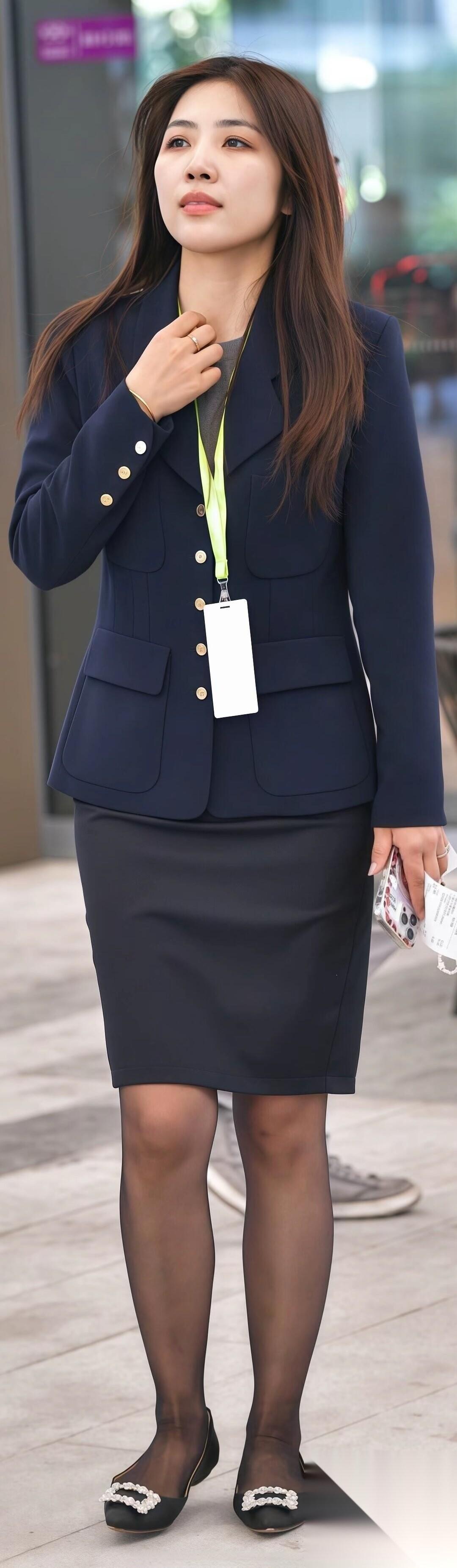 蓝色西装外套+黑色半身裙+黑色丝袜+黑色平底浅口鞋。这套搭配整体偏向稳重、简约、