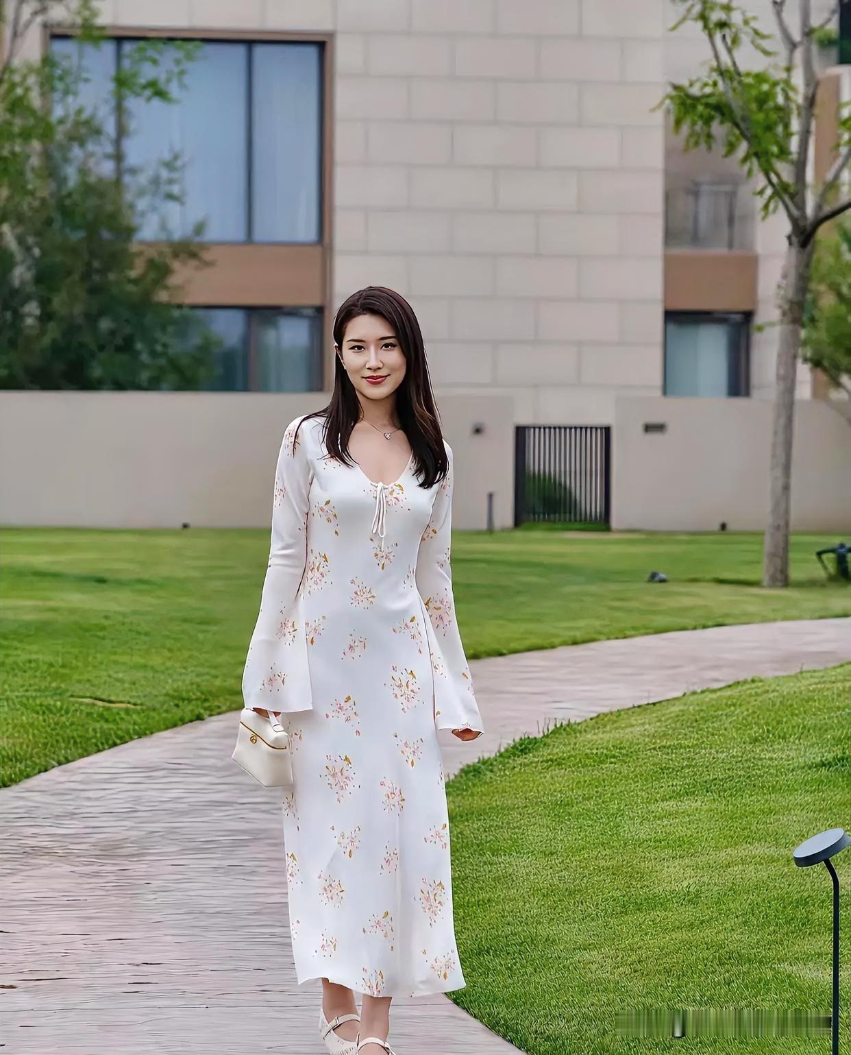 素裙碎花，淡雅如诗。她漫步于青翠之间，裙裾随风轻舞，眉眼含笑，宛若春日晨光，温柔