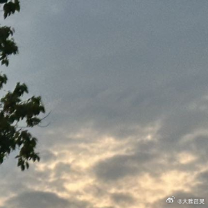 天边铺着层层叠叠的橘粉云层，落日把整座城市都裹进了柔暖的光晕里。路口车来车往，抬
