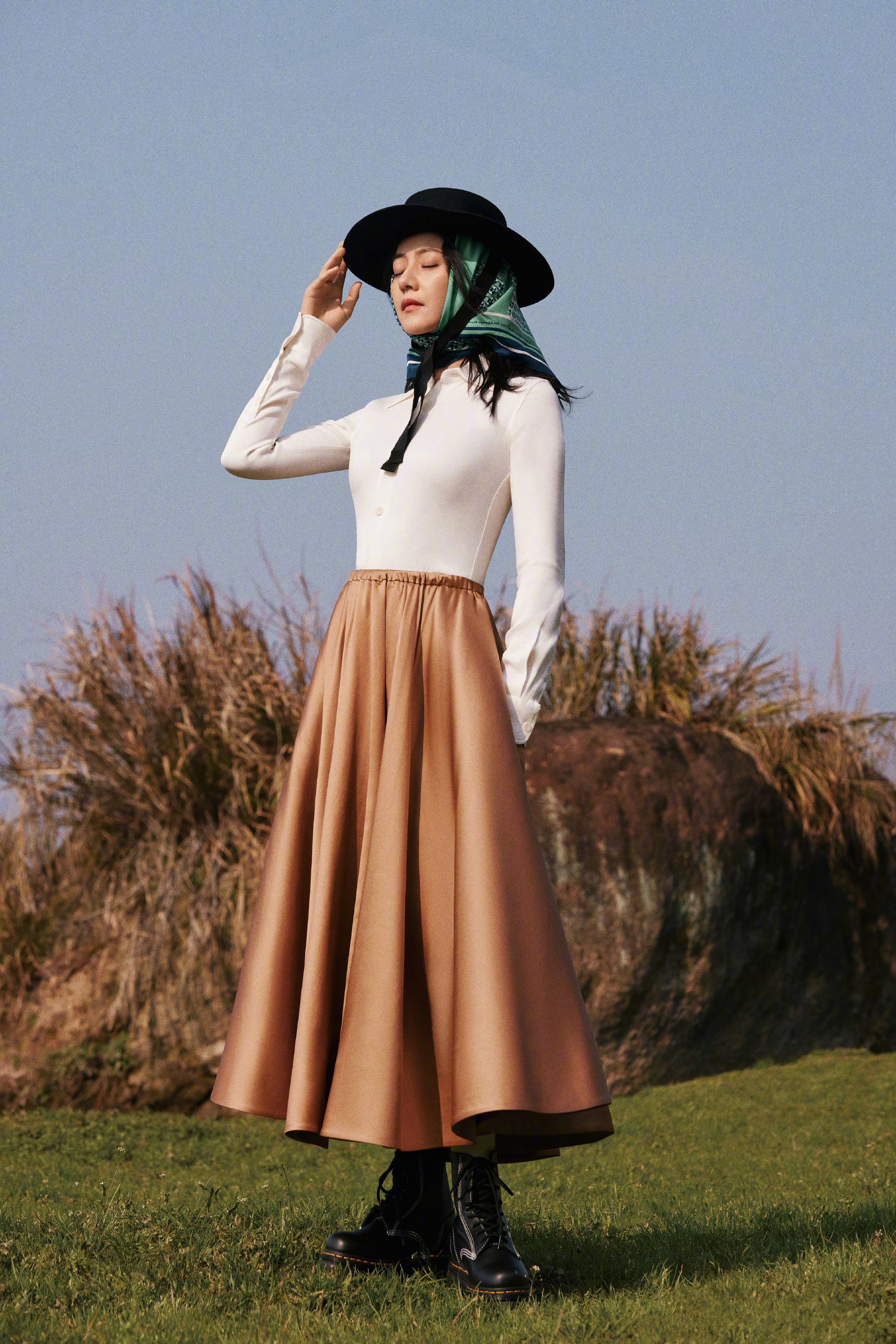 将复古与户外感完美融合，白色修身衬衫勾勒利落线条，焦糖色缎面大摆裙垂坠感十足，自